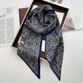 Detailed close-up of paisley pattern satin scarf elegantly displayed on a golden frame - Navy Blue
