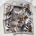 Fashionable silk-like square scarf with tropical monstera leaf print in brown and grey - Khaki