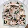 Elegant peach flower print silk scarf in pink and mint green shown on white table - Light Green