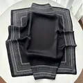 Eleganter schwarzer Seidenschal mit Paisley-Muster auf weißem Tischhintergrund - Schwarz
