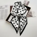 Elegant black and white polka dot silk scarf tied in a bow on a gold tray for women - White