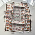 Ivory silk-like square scarf featuring playful rocking horse prints and brown trim - White