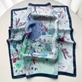 Détail d'un foulard en soie à fleurs bleu et violet avec un ourlet bleu marine chic - Bleu ciel