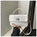 Close-up of a white textured leather mini square bag featuring a silver twist lock detail - White