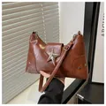 Detail of caramel brown retro shoulder bag featuring a large silver star metal buckle - Brown