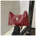 Detail of dark red faux leather shoulder bag featuring large silver metal star buckle - Red