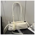 Detail of white glossy underarm bag featuring a large lace bow and long silk ribbons - White