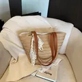 Large straw tote bag with brown leather handles and lace ribbon on a beige chair - Khaki With Scarf
