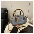 Detail of denim Boston bag with brown leather handles and adjustable shoulder strap - Blue