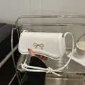Weiße Schultertasche aus Leder mit goldener Schleife und stilvollem Schultergurt - Weiß