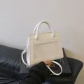Minimalist white PU leather crossbody handbag with top handle and fine stitching detail - White