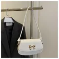 Détail du sac bandoulière en cuir blanc avec fermoir nœud doré et sangle à nœuds - Blanc
