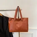 Vue détaillée du grand sac cabas en similicuir marron avec coutures et bandoulières - Marron Jaune