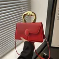 Chic red textured handbag with artistic golden metal handle and crossbody strap - Red
