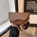Borsa a sella marrone a semicerchio con ampia tracolla a righe e patta dal design asimmetrico - caffè