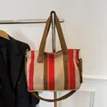 Striped canvas tote bag with red, cream, orange and brown patterns in a casual style - Red