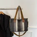 Large striped canvas tote bag with brown handles and adjustable crossbody strap - Black