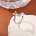Silver V-shaped open ring with cubic zirconia inlay on a white stone background - Style Letter V