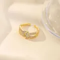 Detailed view of an 18K gold plated adjustable ring with pavé-set shimmering zircon stones - Interlocking Buckle Knot Design (Style H)