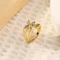 Macro detail of 18K gold-plated flower ring with marquise zircon and black accents - Four-Petal Floral Shape (Style K)