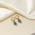 Detailed macro of teardrop ruby in zoisite earrings with elegant golden hoops - Olive Green