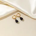 Elegant gold hoop earrings with dark blue teardrop stones on luxury champagne silk - Black
