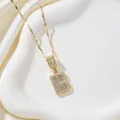 Golden letter B pendant necklace with baguette-cut stones on a silk display - Letter B