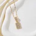 Collier doré avec pendentif carré orné de la lettre E en zircons sertis de style pavé - Lettre E