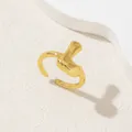 Dettaglio anello dorato regolabile con design minimalista dalle forme organiche - Oro Lettera-L