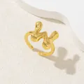 Dettaglio ravvicinato di un anello regolabile dorato con texture metallica fluida - Oro Lettera-W