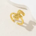 Primo piano di un anello regolabile placcato oro lucido con design a lettera geometrica astratta - Oro Lettera-F