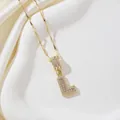 Collier luxe avec pendentif lettre L dorée sertie de zircons sur fond de tissu en soie - Lettre L