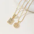 Detailed macro view of two gold letter B pendants with sparkling cubic zirconia settings - B Pendant And Necklace