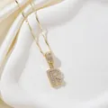 Collier doré avec pendentif lettre R orné de zircons cubiques sur plateau blanc - Lettre R