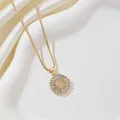 Close-up of gold pendant with letter C and cubic zirconia in a jewelry tray - Letter C