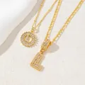 Dettaglio della collana con pendente lettera L placcata oro con zirconi e pietre baguette - Lettera L