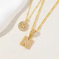 Dettaglio di collane placcate oro con pendenti lettera N e pietre di zircone - Lettera N