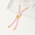 Detail of pink woven cord bracelet featuring adjustable gold slider and metallic ends - Pink