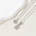 Silver letter B pendant necklace with sparkling diamonds on textured beige background - Letter B(B)
