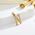 Gouden letter N hanger met schors-textuur op een wit stenen voetstuk display - Stijl N Alleen Hanger (Zonder Ketting)