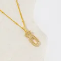 Collier doré avec lettre O à couronne serti de zircons sur un fond minimaliste chic - Lettre O
