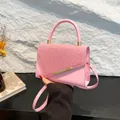Chic pink top handle bag with woven texture flap and golden hardware accents - Pink