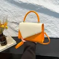 Orange and beige woven top handle bag with gold hardware and a slim shoulder strap - Orange