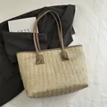 Beige Stroh-Tragetasche mit braunen Ledergriffen und Knotendetail für die Sommermode - Khaki