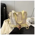 Detail of straw woven bucket bag with elegant white lace bow and yellow leather accents - Yellow