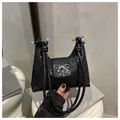 Detail einer schwarzen gewebten Handtasche mit silberner Schmetterlingsschnalle und Knotengriff - Schwarz