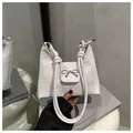 Detail der weißen geflochtenen Ledertasche mit silberner Schleife und Knotendesign - Weiß