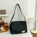 Bolso mensajero minimalista en denim negro con correa ajustable y etiqueta tejida - Negro