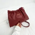 Burgundy woven leather bucket bag with gold logo and shoulder strap in summer style - Red