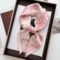 Dettaglio di un foulard in seta rosa con motivi a ciliegia e bordi floreali su un vassoio - Rosa / Motivo Paisley Ciliegia Rosa